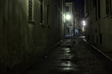 Gece hafif bir yağış sırasında İtalyan kasabasında bir sokak.