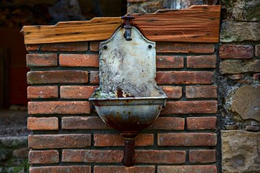 Tuğla duvardaki çeşme.