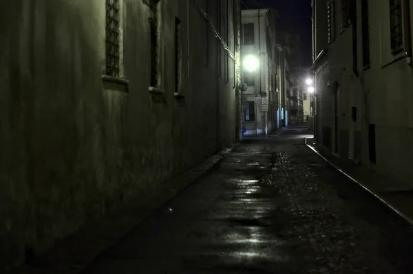 Gece hafif bir yağış sırasında İtalyan kasabasında bir sokak.
