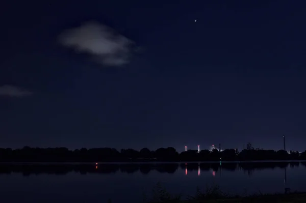 Озеро Ночью Фабрикой Вдалеке — стоковое фото