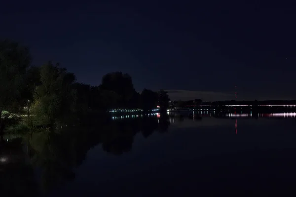 夜晚在公园旁边的一座湖上的桥 — 图库照片