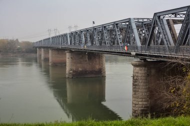 Sonbaharda gün batımında tren yolu köprüsü bulutlu bir günde