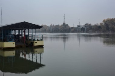 Nehrin diğer tarafında fabrikası olan bir tekne.