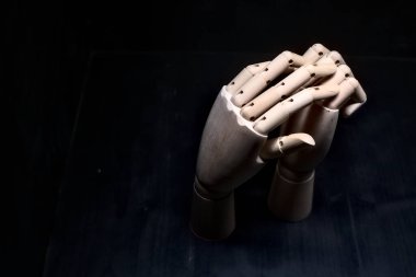 Başka bir tahta eli sıkıca kapalı tutmaya çalışan tahta bir el.