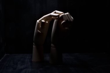 Başka bir tahta eli sıkıca kapalı tutmaya çalışan tahta bir el.