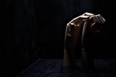 Başka bir tahta eli sıkıca kapalı tutmaya çalışan tahta bir el.