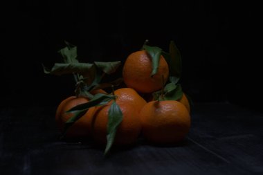 Siyah bir yüzey üzerinde mandalinalar