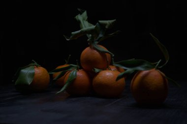 Siyah bir yüzey üzerinde mandalinalar