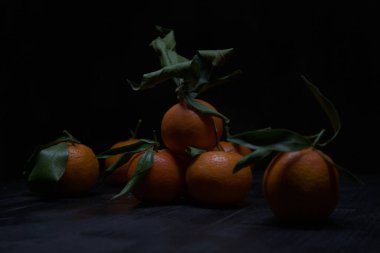 Siyah bir yüzey üzerinde mandalinalar