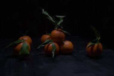 Siyah bir yüzey üzerinde mandalinalar