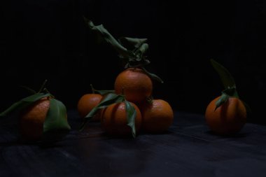 Siyah bir yüzey üzerinde mandalinalar