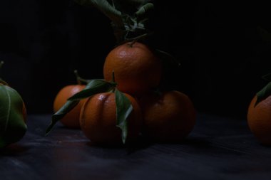 Siyah bir yüzey üzerinde mandalinalar
