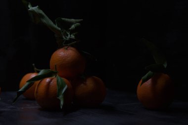 Siyah bir yüzey üzerinde mandalinalar