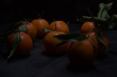 Siyah bir yüzey üzerinde mandalinalar
