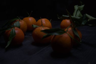 Siyah bir yüzey üzerinde mandalinalar