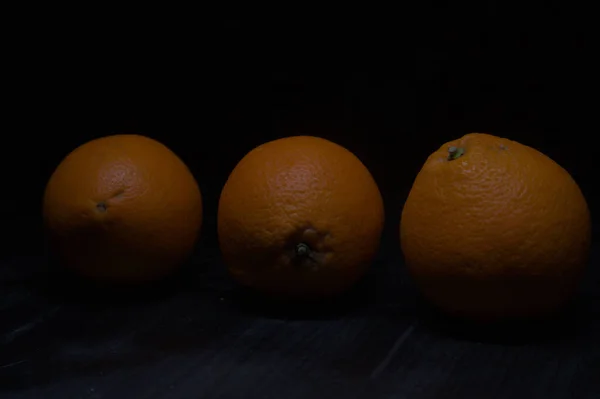 Oranges on a black surface