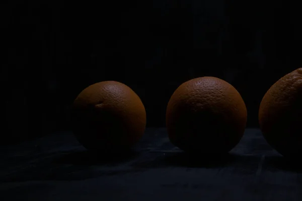 Oranges on a black surface
