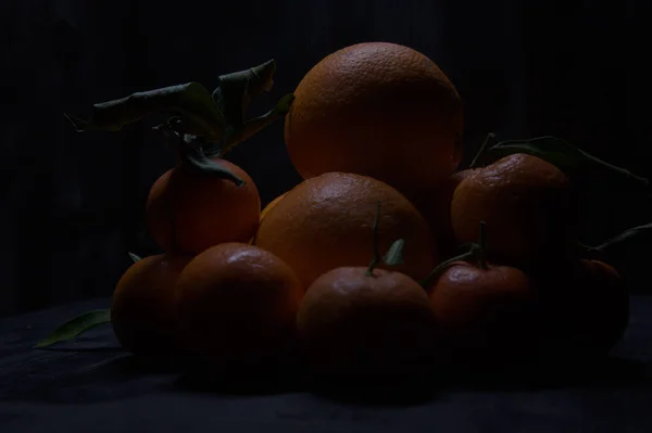Sinaasappelen Mandarijnen Samen Gestapeld Een Zwart Oppervlak — Stockfoto