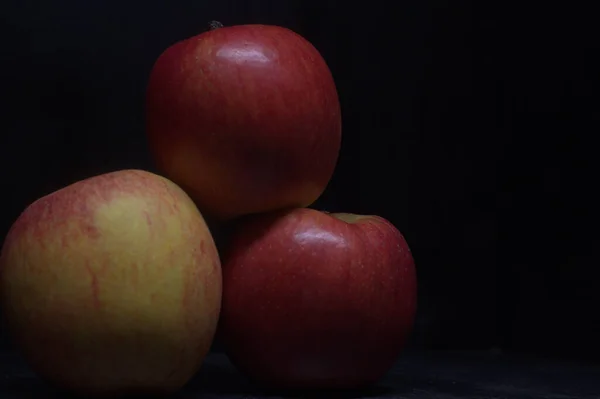黑色表面上的红苹果和黄苹果 — 图库照片