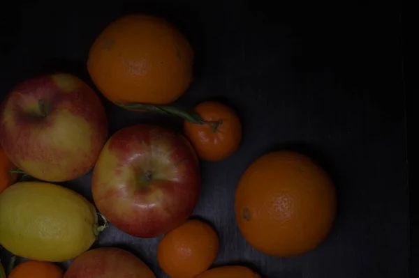 Tangerinas Maçãs Com Limões Laranjas Uma Superfície Preta — Fotografia de Stock