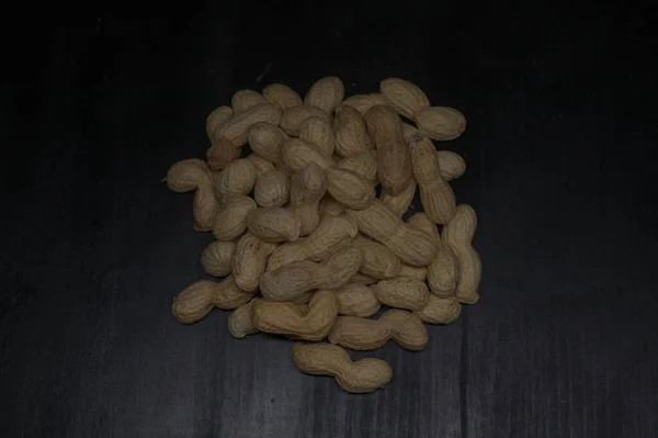 Amendoins Uma Superfície Preta — Fotografia de Stock