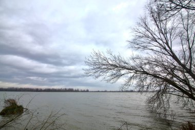 Kışın İtalya kırsalında bulutlu bir günde bir nehrin kıyısında