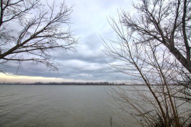 Kışın İtalya kırsalında bulutlu bir günde bir nehrin kıyısında