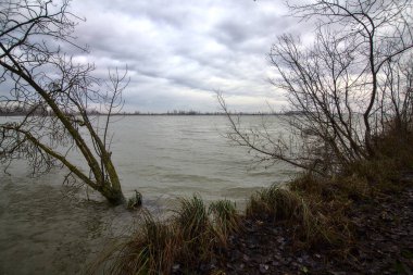 Kışın İtalya kırsalında bulutlu bir günde bir nehrin kıyısında