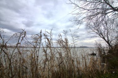 Kışın İtalya kırsalında bulutlu bir günde bir nehrin kıyısında