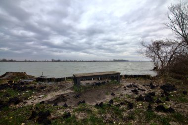 Kışın İtalya kırsalında bulutlu bir günde bir nehrin kıyısında