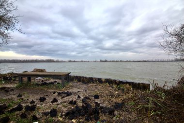 Kışın İtalya kırsalında bulutlu bir günde bir nehrin kıyısında