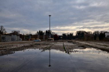 Terk edilmiş bir yerleşkede demiryolunun yanındaki su birikintisine atılmış.