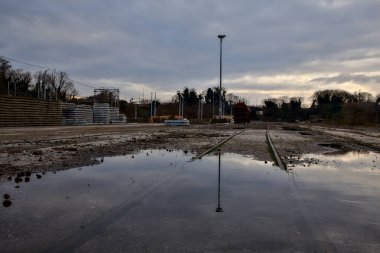 Terk edilmiş bir yerleşkede demiryolunun yanındaki su birikintisine atılmış.