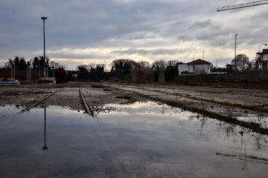 Terk edilmiş bir yerleşkede demiryolunun yanındaki su birikintisine atılmış.