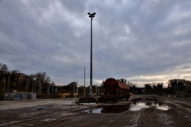 Terk edilmiş bir yerleşkede demiryolunun yanındaki su birikintisine atılmış.