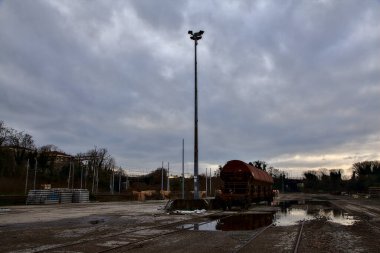 Terk edilmiş bir yerleşkede demiryolunun yanındaki su birikintisine atılmış.