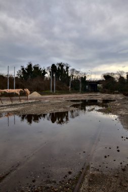 Terk edilmiş bir yerleşkede demiryolunun yanındaki su birikintisine atılmış.