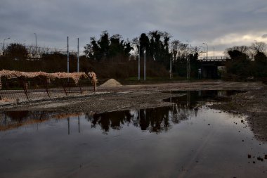 Terk edilmiş bir yerleşkede demiryolunun yanındaki su birikintisine atılmış.