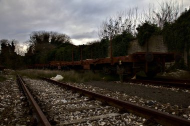 Terk edilmiş tren nakliye vagonları kullanılmayan bir yerleşkenin çıkmaz sokaklarında.