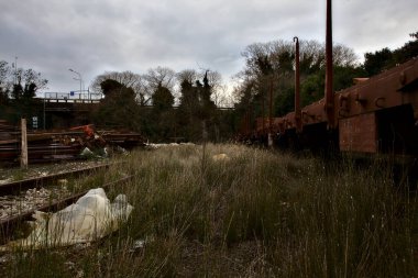 Terk edilmiş tren nakliye vagonları kullanılmayan bir yerleşkenin çıkmaz sokaklarında.
