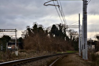 Kışın İtalya 'nın kenar mahallelerindeki bir istasyonun yanındaki demiryolu rayları.