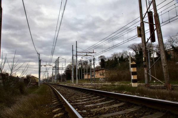 Railroad tracks next to a station in the outskirts of an italian town in winter