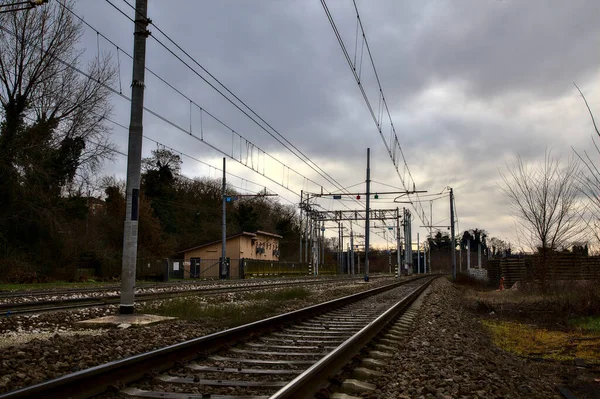 冬にイタリアの町の郊外にある駅の隣の鉄道線路 — ストック写真