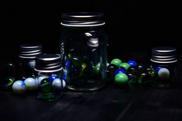 Tarro Con Canicas Colores Sobre Una Superficie Negra — Foto de Stock