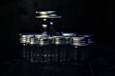 Siyah bir yüzeye boş küçük kavanozlar.