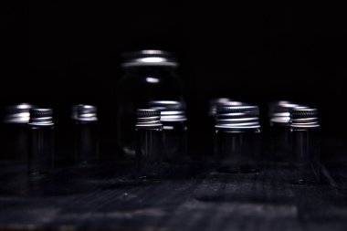 Siyah bir yüzeye boş küçük kavanozlar.