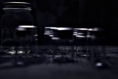 Siyah bir yüzeye boş küçük kavanozlar.