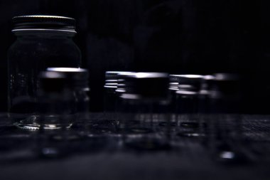 Siyah bir yüzeye boş küçük kavanozlar.