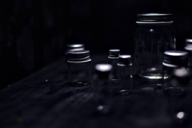 Siyah bir yüzeye boş küçük kavanozlar.