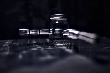 Siyah bir yüzeye boş küçük kavanozlar.